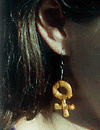 Foto av örhänge i form av ett kvinnomärke
