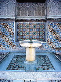 Foto av mosaik i blåa mönster och en fontän