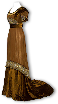 Guldbrun klänning med släp och vackra, breda dekorationsband i jugendstil