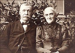 Foto av Robert och Ellen på äldre dar, de sitter på en bänk utomhus, bägge ler och ser in i kameran