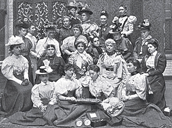 En grupp kvinnor i 1800-talskläder, där de som sitter längst fram håller i ett schackspel