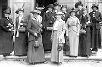 Foto av de slesta i den svenska delegationen iförda hattar och långa kappor