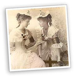 Foto av Constance och Eva klädda i gammaldags ljusa klänningar med spetsar och spetshattar