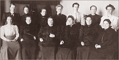 Foto av 13 kvinnor som sitter och står bakom varandra