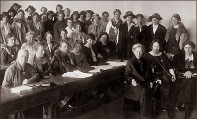 Foto av en stor samling kvinnor som sitter och står om vartannat