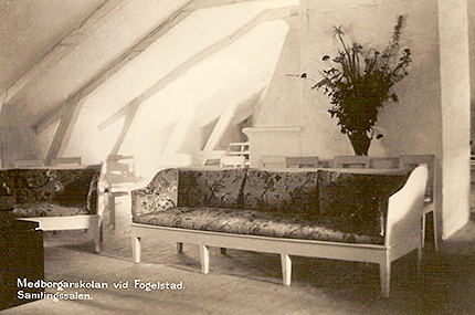 Interiörbild med soffor, stolar, snedtak och blommor