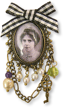 Bild av smycke, en medaljong med bild av Annie Kenney och pärlor och kedjor samt en svartvit rosett överst