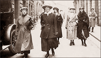 Foto av Eva Andén med flera gåenden på en gata . Till vänster skymtar en bil. Längst bak till höger står en man och tittar efter gruppen av kvinnor.