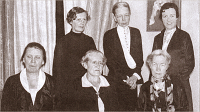 Foto av sex kvinnor, tre sittande och tre stående. Det enda som syns av bakgrunden är gardiner/draperier och aningen av ett foto