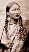 Foto av en irokes-kvinna. Hon har flätor och halsband och ser åt höger i bild