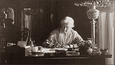 Foto av Elizabeth Smith Miller på äldre dar där hon sitter vid ett skrivbord och skriver