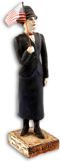 Figur/statyett av kvinna i dräkt med en amerikansk flagga i handen och på sockeln står: Equal suffrage