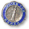Gammaldags rösträttsrockmärke i silver med en blå rand där det står "Votes for Women" och rättvisans gudinna i mitten