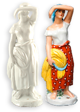 Två porslinsfigurer av samma modell. Den vänstra är av omålat proslin, medan den röda är en kvinna i röd kjol med vita prickar som håller en skära och säd i ena handen, Men den andra torskar hon av svetten. Hon har en ljusblå sjal på huvudet.