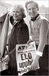 Foto av leende Amelie Posse och hennes ena son, som håller upp en löpsedel som det står "Rld upphör" på