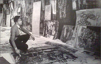 Foto av Siri Derkert sittande på huk med väggar och golv täckta av konstverk
