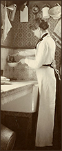 Foto av tjänstekvinna som står och fyller vatten i en skopa i ett gammaldags kök