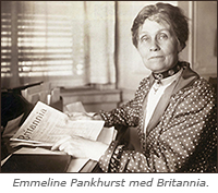 Foto av en kvinna i halvfigur som sitter vid ett skrivbord och håller i ett nummer av tidningen Britannia. Hon ser in i kameran. Under bilden står: Emmeline Pankhurst med Britannia