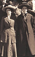 Foto av Rose Schneiderman och Agnes Nestor stående utomhus. Bägge har kappor och hatt, de står rakt upp och ned och blickar framför sig.