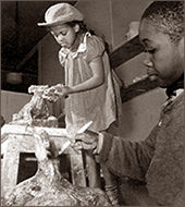 Foto av en liten flicka och en liten pojke, båda arbetar med skulpturer