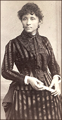 Foto av Lucy Parsons vid ung ålder, iförd en randig sidenklänning med spets i halsen