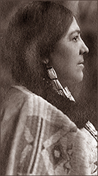 Det officiella porträttfotot av Marie Louise Bottineau Baldwin på Bureau of Indian Affaires 1911, hon står i profil med flätor och traditionell klädsel