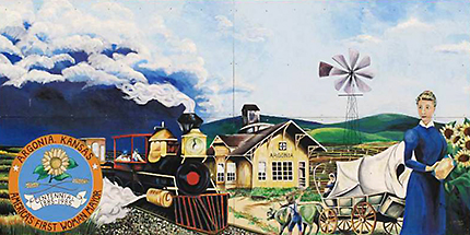 Muralmålning med ett tåg som kommer farande, ett gult hus som det står Argonia på, en prärievagn och en kvinna i blått till höger i bild och diverse annat