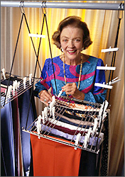 Foto av Marion Donovan på äldre dar där hon står framför sin uppfinning för garderobssortering.
