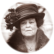 Porträttfoto av Alva Belmont på äldre dar, iförd hatt. Runt halsen hänger ett smycke och en päls anas