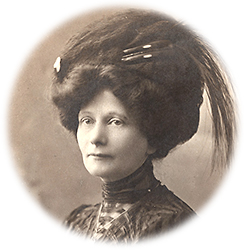 Porträttfoto av Mary Clarke iförd en stor hatt med fjädrar