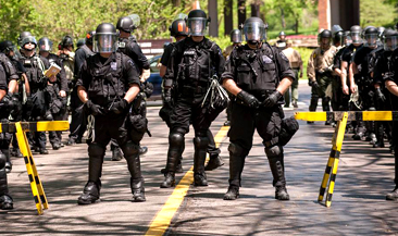 Kravallklädda poliser uppställda vid en väg