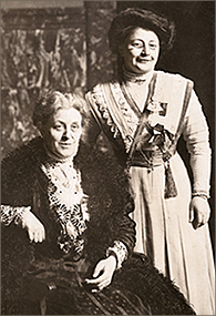 Foto av Carrie Chapman Catt som sitter ner och Rosa Manus som står snett bakom henne