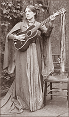 Foto av May Morris stående med en gitarr i händerna